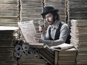 Young man in old fashioned costume making research among newspapers, looking through magnifying glass
