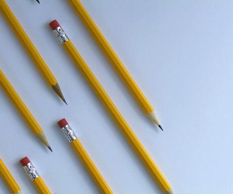 Several yellow pencils on diagonal and parallel to each other on white